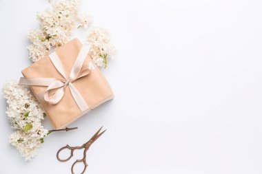 Beyaz arka planda güzel leylak çiçekleri, hediye ve makas