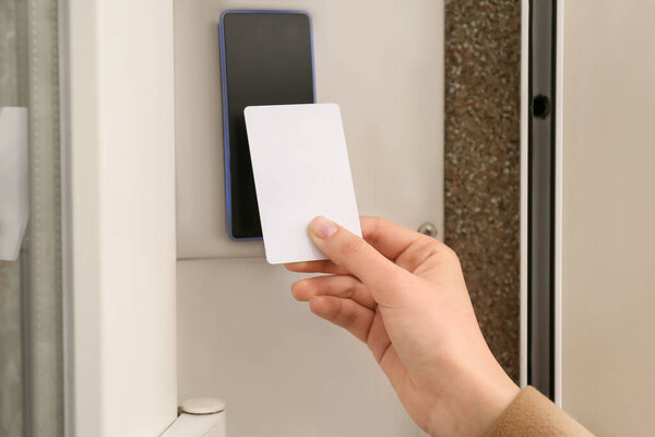 Женщина, открывающая дверь с охранной картой снаружи
