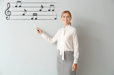 Sınıfta tahtaya yakın güzel bir müzik öğretmeni.