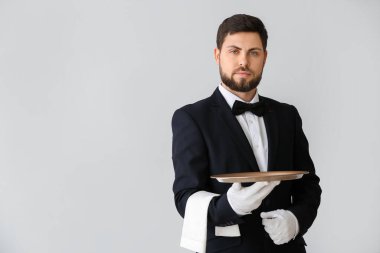 Gri arka planda yakışıklı erkek garson.