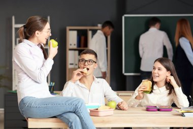 Öğrenciler sınıfta öğle yemeği yiyor.