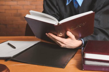 Kadın yargıç mahkeme salonundaki masada kitap okuyor, yakın plan.