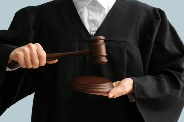 Arka planda tokmağı olan kadın yargıç, yakın plan.