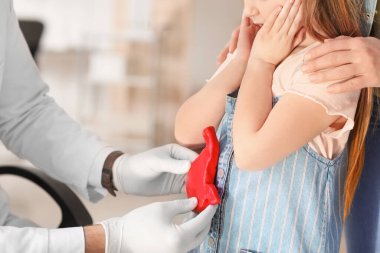 Küçük kızıyla birlikte bir kadın klinikte gastroenteroloğu ziyaret ediyor.