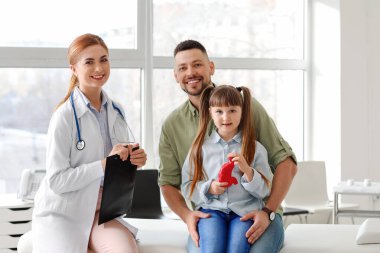 Küçük kızıyla birlikte bir adam klinikte gastroenteroloğu ziyaret ediyor.