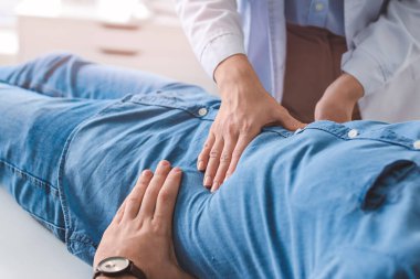 Gastroenterolog klinikteki adamı inceliyor.