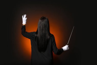 Karanlık arka planda genç bir kadın şef.