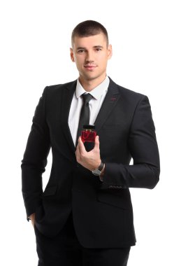 Beyaz arka planda parfüm şişesi olan yakışıklı bir genç.