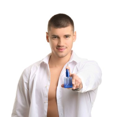 Beyaz arka planda parfüm şişesi olan yakışıklı bir genç.