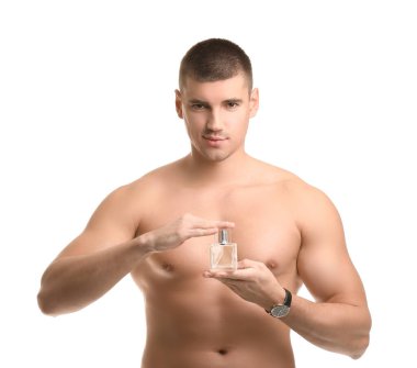 Beyaz arka planda parfüm şişesi olan yakışıklı bir genç.