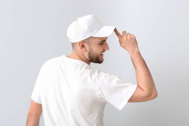 Hafif arka planda şık şapkalı yakışıklı bir adam.