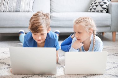Evde dizüstü bilgisayarı olan şirin çocuklar. Çevrimiçi eğitim kavramı
