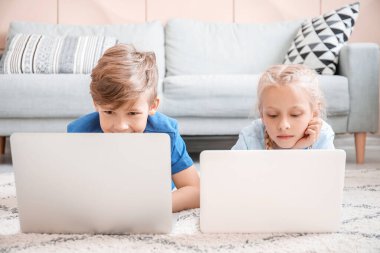 Evde dizüstü bilgisayarı olan şirin çocuklar. Çevrimiçi eğitim kavramı