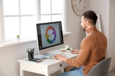 Evde çalışan genç erkek tasarımcı.