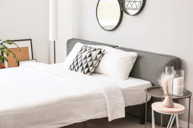 Odasında temiz çarşaf olan büyük, rahat bir yatak.