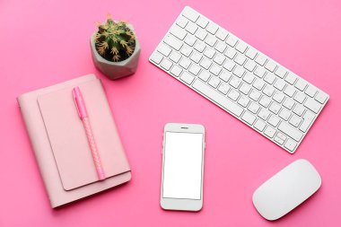 Renk arkaplanında bilgisayar ve defter olan modern cep telefonu