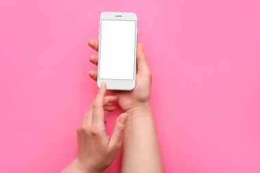 Renkli arka planda cep telefonu olan kadın elleri