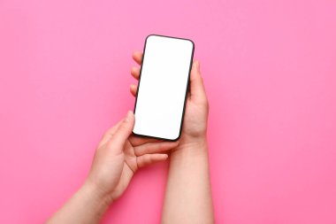 Renkli arka planda cep telefonu olan kadın elleri