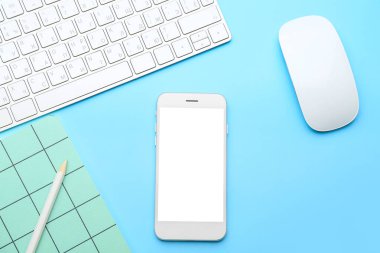 Renk arkaplanında bilgisayar ve defter olan modern cep telefonu