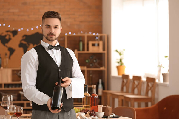 Официант с бутылкой вина в ресторане
