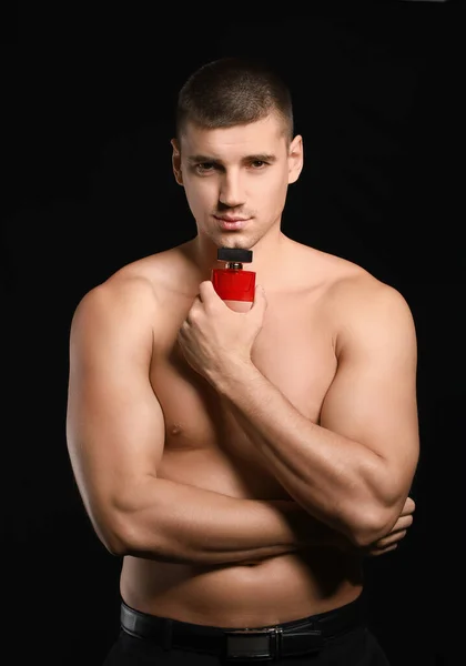 Joven Guapo Con Botella Perfume Sobre Fondo Oscuro — Foto de Stock