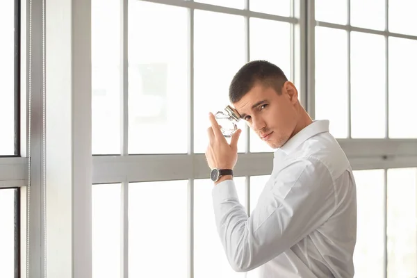 Knappe Jongeman Met Fles Parfum Bij Het Raam — Stockfoto