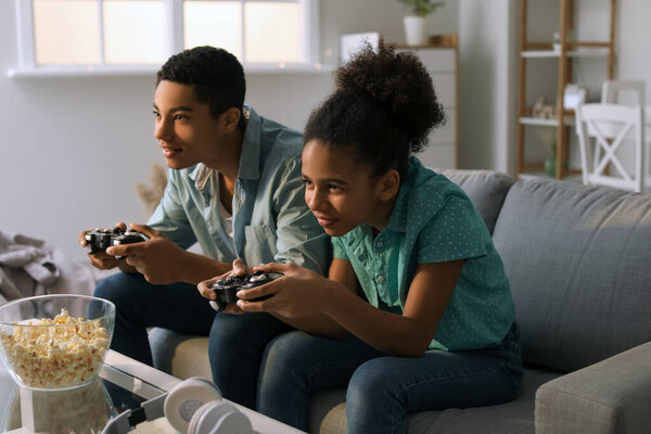 Афроамериканские подростки играют в видеоигры дома
