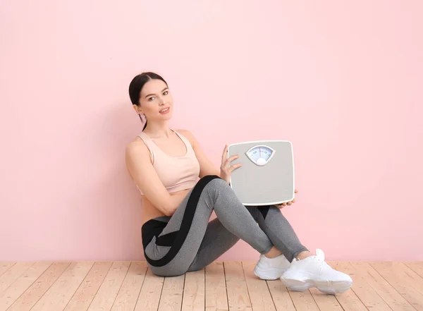 Mujer Joven Con Escalas Medición Sentada Cerca Pared Color —  Fotos de Stock