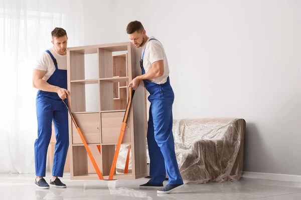 Loaders carrying furniture in flat