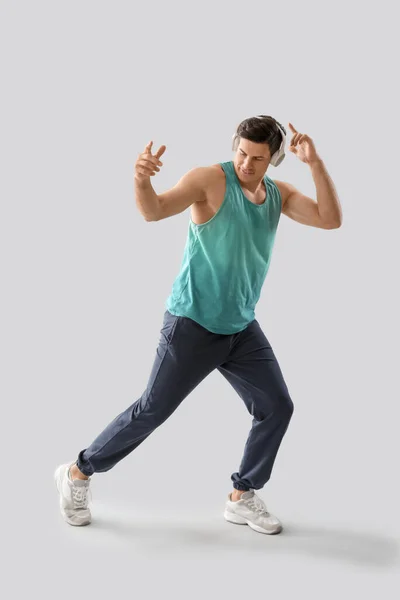 Joven Guapo Escuchando Música Sobre Fondo Claro — Foto de Stock