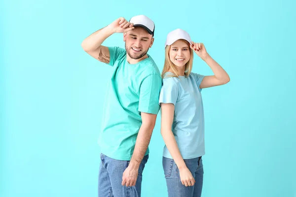 Pareja Joven Elegantes Gorras Sobre Fondo Color — Foto de Stock