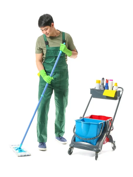 Male janitor with cleaning supplies on white background