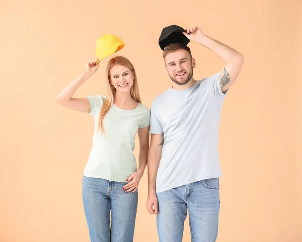 Jong Paar Met Stijlvolle Caps Kleur Achtergrond — Stockfoto