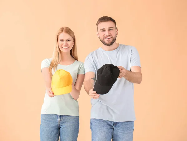 Casal Jovem Com Bonés Elegantes Fundo Cor — Fotografia de Stock