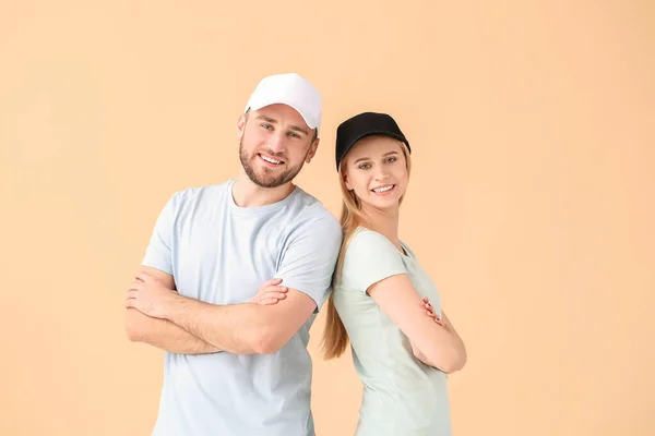 Junges Paar Stylischen Kappen Auf Farbigem Hintergrund — Stockfoto