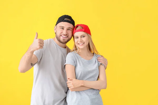 Young Couple Stylish Caps Showing Thumb Gesture Color Background — Stock Photo, Image