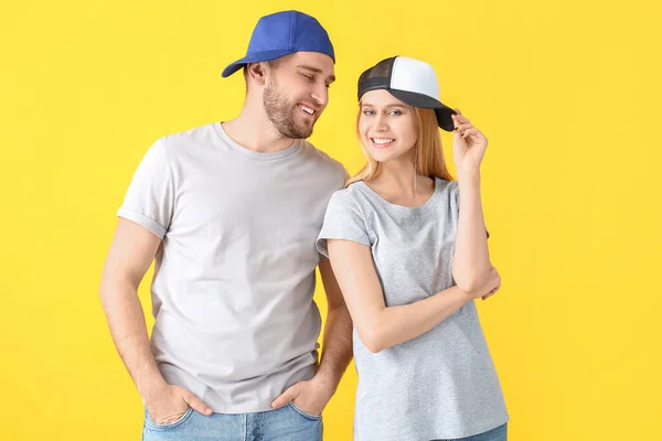 Pareja Joven Elegantes Gorras Sobre Fondo Color — Foto de Stock