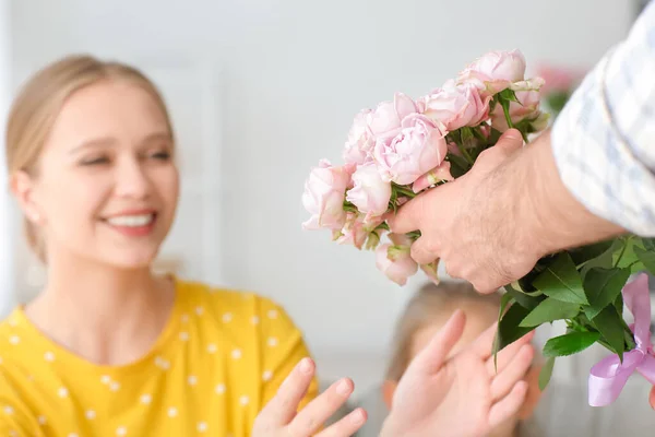 Man giving bouquet of flowers for his wife at home