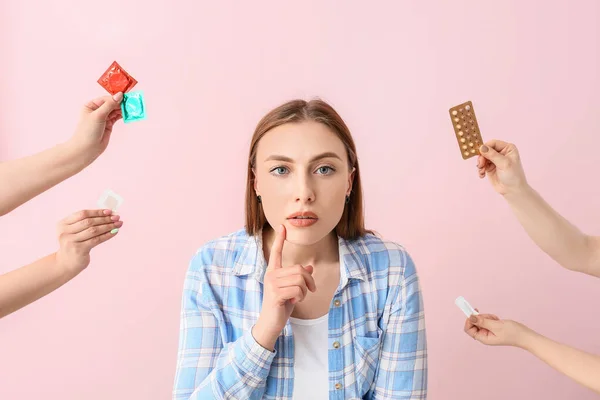 Junge Frau Und Hände Mit Verschiedenen Verhütungsmitteln Auf Farbigem Hintergrund — Stockfoto