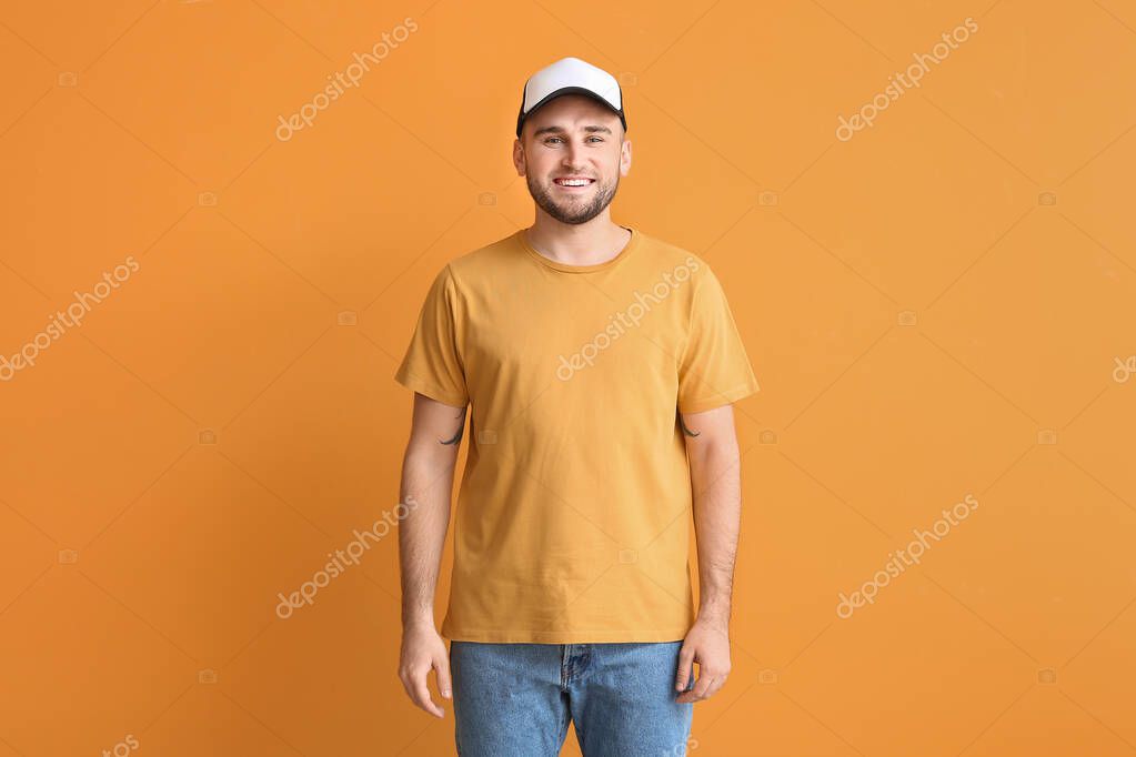 Handsome man in stylish cap on color background