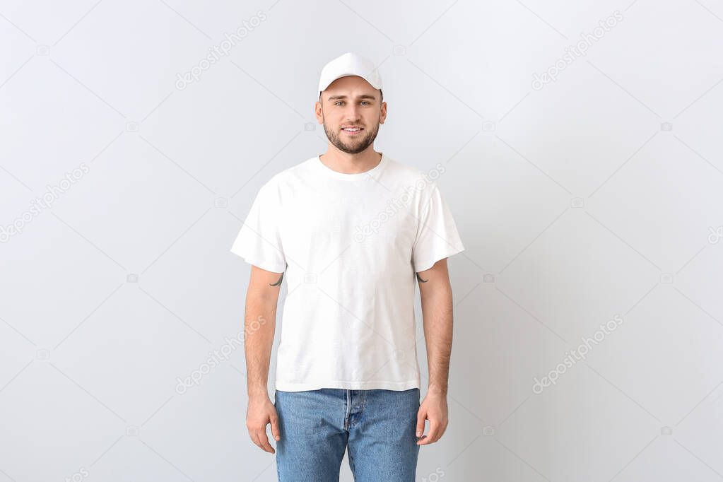 Handsome man in stylish cap on light background