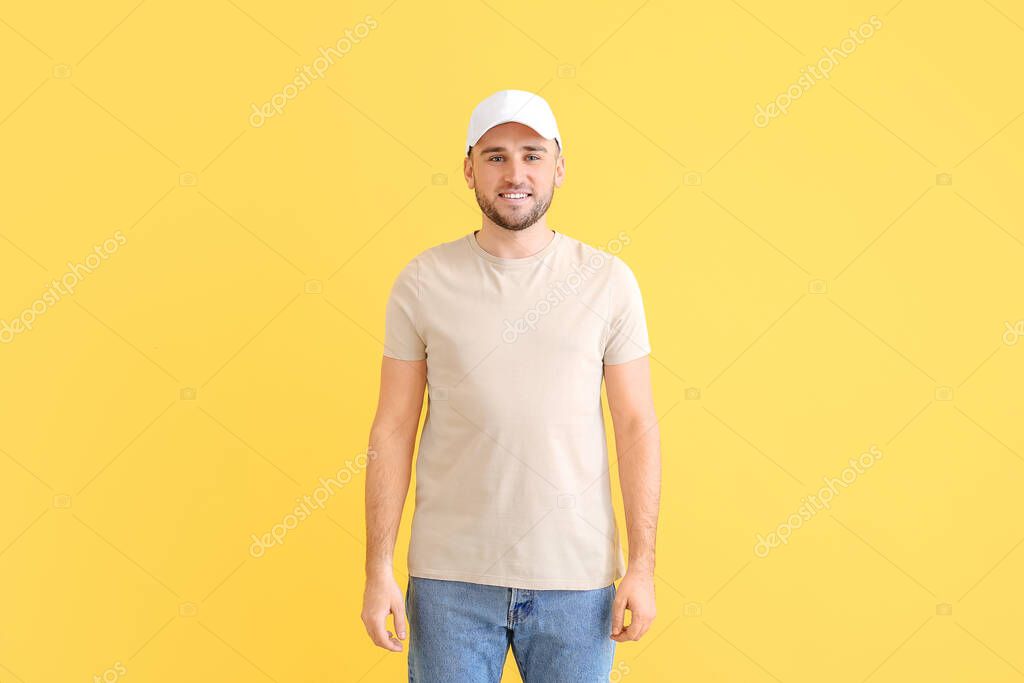 Handsome man in stylish cap on color background