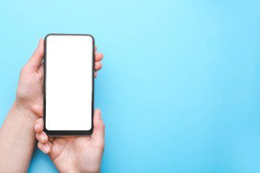 Renkli arka planda cep telefonu olan kadın elleri