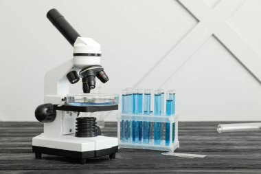 Modern mikroskop ve test tüpleri masada.
