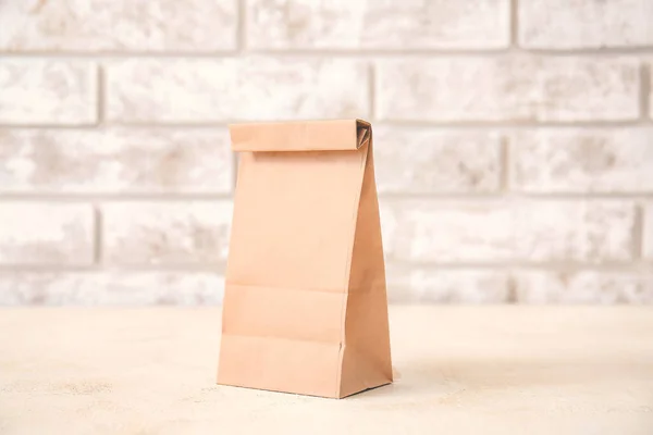 Paper bag on table against light background