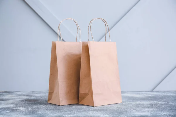 Papieren Zakken Tafel Tegen Een Lichte Achtergrond — Stockfoto