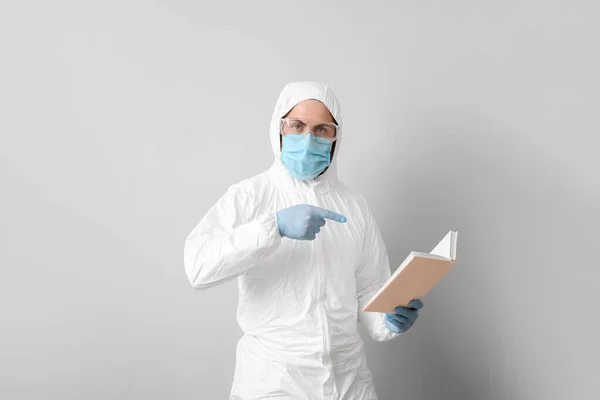 Man Biohazard Suit Reading Book Grey Background — Stock Photo, Image