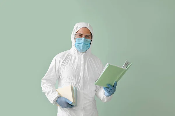 Man Biohazard Suit Reading Book Color Background — Stock Photo, Image