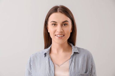 Gri arka planda genç bir kadın