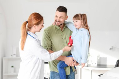 Küçük kızıyla birlikte bir adam klinikte gastroenteroloğu ziyaret ediyor.